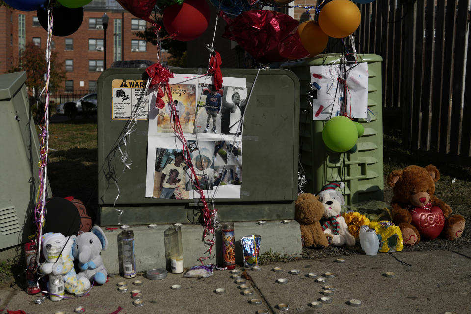 Balloons, stuffed animals, and photographs are seen at a makeshift memorial for Dominic Davis, an 11-year-old boy, who was killed in a weekend shooting, Monday, Nov 6, 2023, in Cincinnati. Police Chief Terri Theetge told reporters Sunday that a shooter in a sedan fired 22 rounds "in quick succession" into a crowd of children just before 9:30 p.m. Friday on the city's West End. (AP Photo/Carolyn Kaster)
