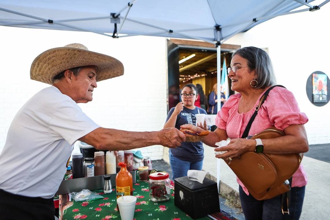 Julio Coronel, left, hands churros from the food truck El Churro Del 8 at Camino Celebra Arte & Cultura, an event celebrating the beginning of Hispanic Heritage Month, on Thursday, September 15, 2022 in Charlotte, NC.