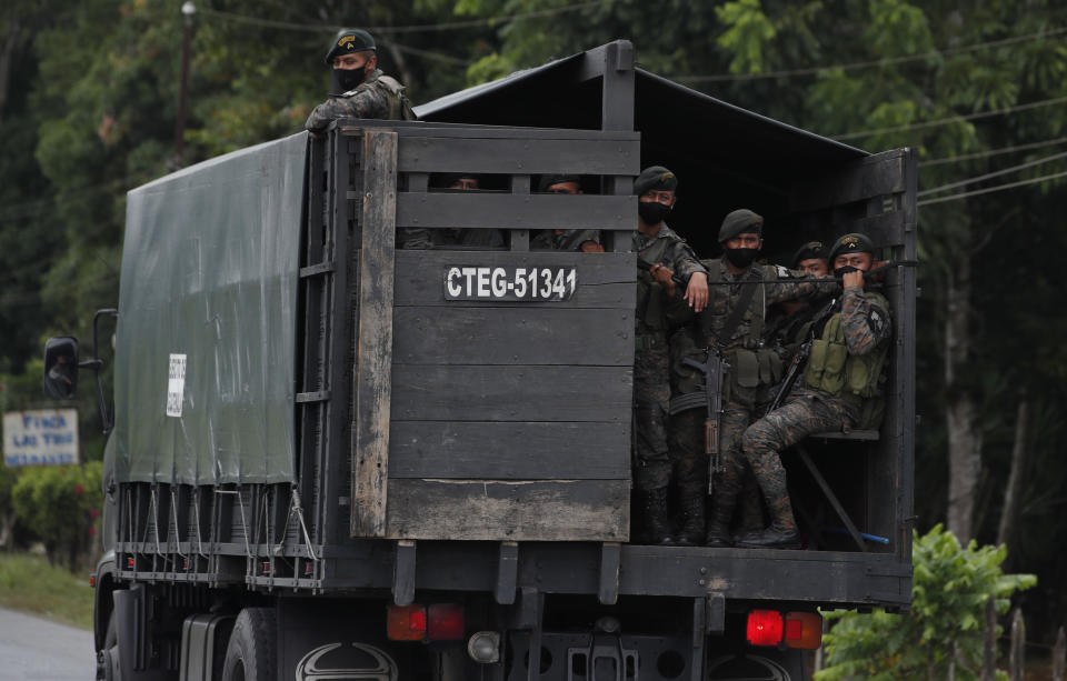 Guatemalan soldiers wait in Morales, Guatemala, on the lookout for migrants near the Honduran border, Friday, Oct. 2, 2020. Guatemala vowed to detain and return members of a new caravan of about 2,000 migrants that set out from neighboring Honduras in hopes of reaching the United States, saying they represent a health threat amid the coronavirus pandemic. (AP Photo/Moises Castillo)