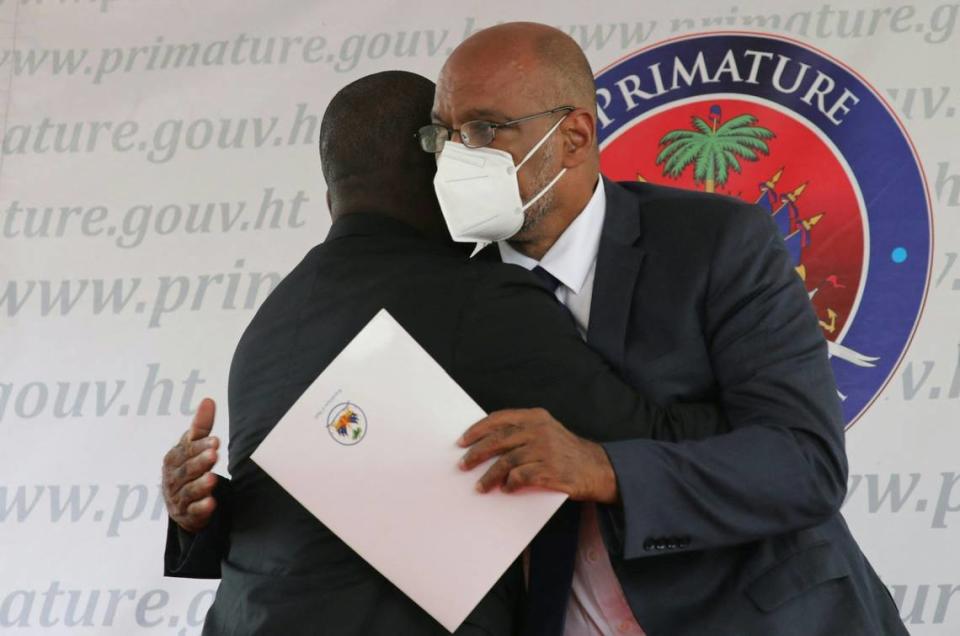 Interim Prime Minister Claude Joseph, left, hugs designated Prime Minister Ariel Henry during a ceremony at La Primature in Port-au-Prince, Haiti, on July 20, 2021. The ceremony comes as designated Prime Minister Ariel Henry prepared to replace interim Prime Minister Claude Joseph after the July 7 attack at the president’s private home.