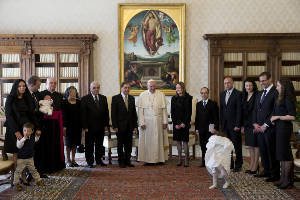 Pope Francis poses for photographers with Malta's President George Abela, at this left, and members of his family and delegates during a private audience in the Pontiff's studio, at the Vatican, Friday, March 21, 2014. (AP Photo/Andrew Medichini, Pool)