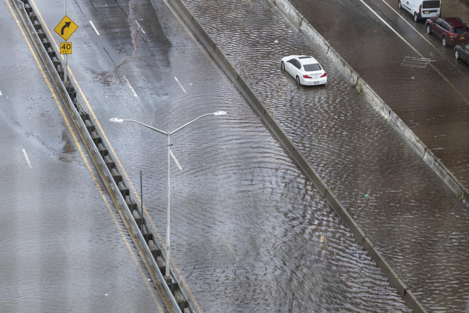 An abandoned car sits in flood waters on the FDR highway in the Lower East Side of Manhattan on Friday, Sept. 29, 2023 in New York. A potent rush-hour rainstorm swamped the New York metropolitan area on Friday, shutting down some subways and commuter railroads, flooding streets and highways, and delaying flights into LaGuardia Airport. (AP Photo/Stefan Jeremiah)