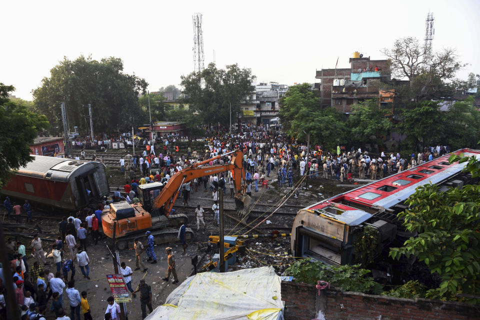 Rescuers and other gather around coaches of the North-East Express passenger train that derailed late Wednesday near Raghunathpur railroad station in Buxar district of Bihar state, India, Thursday, Oct.12, 2023. The train was on its way to Assam state from New Delhi. (AP Photo/Aftab Alam Siddiqui)