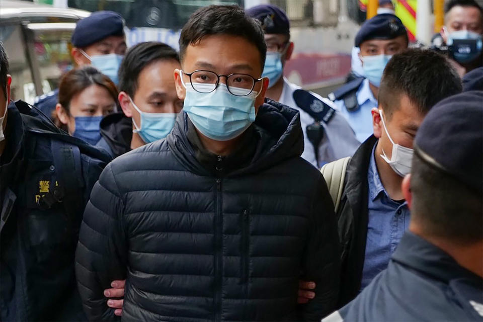 TOPSHOT - Stand News chief editor Patrick Lam is brought to the news outlet's office building in handcuffs after police were deployed to search the premises in Hong Kong's Kwun Tong district on December 29, 2021. (Photo by Daniel SUEN / AFP) (Photo by DANIEL SUEN/AFP via Getty Images)