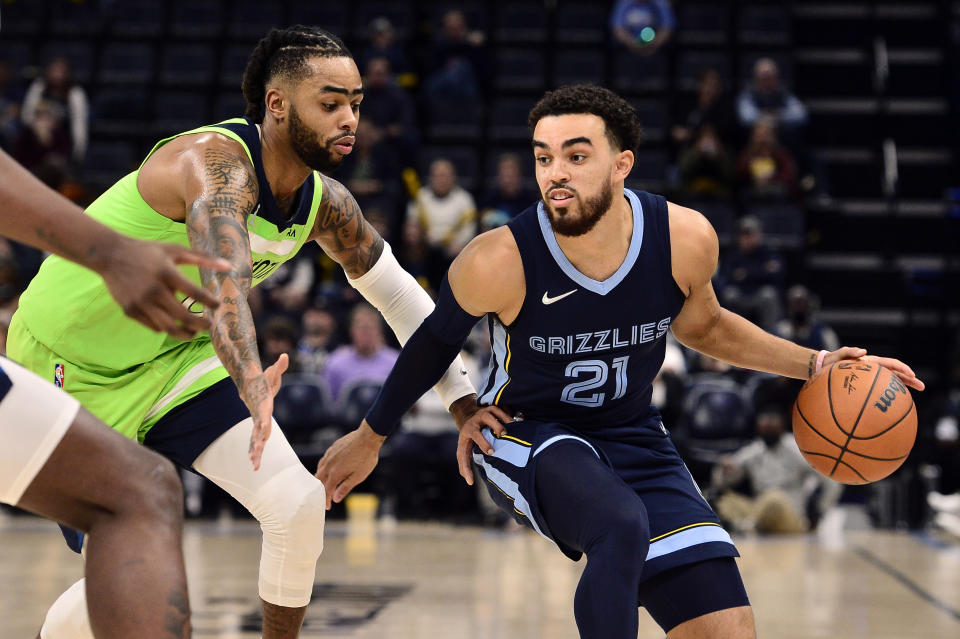 Memphis Grizzlies guard Tyus Jones (21) handles the ball against Minnesota Timberwolves guard D'Angelo Russell in the second half of an NBA basketball game Monday, Nov. 8, 2021, in Memphis, Tenn. (AP Photo/Brandon Dill)