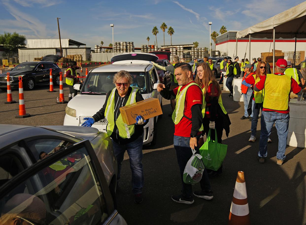Volunteers load food and turkeys into people's cars and trucks during an annual Thanksgiving food distribution at St. Mary's Food Bank on Nov. 22, 2022.