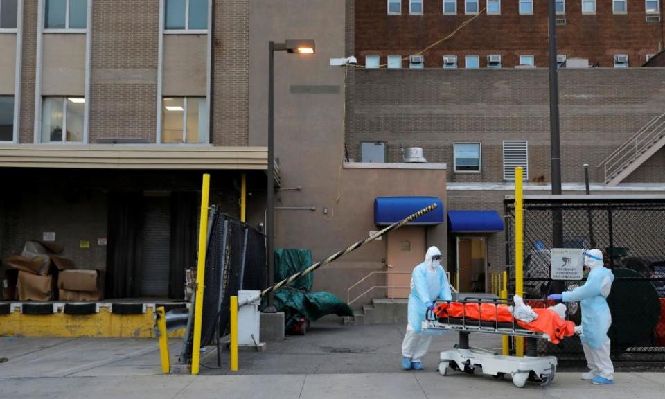 Workers wheel a body from the Wyckoff Heights medical center during the coronavirus outbreak in New York. Trump has told governors to find life-saving equipment on their own.