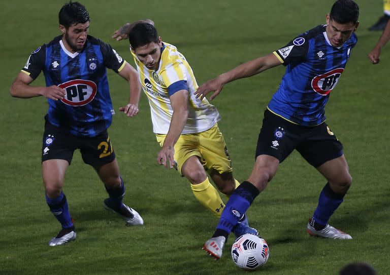 Rodrigo Villagra compite por la pelota con un futbolista de Huachipato de nombre sensible para Rosario Central: Maximiliano Rodriguez.