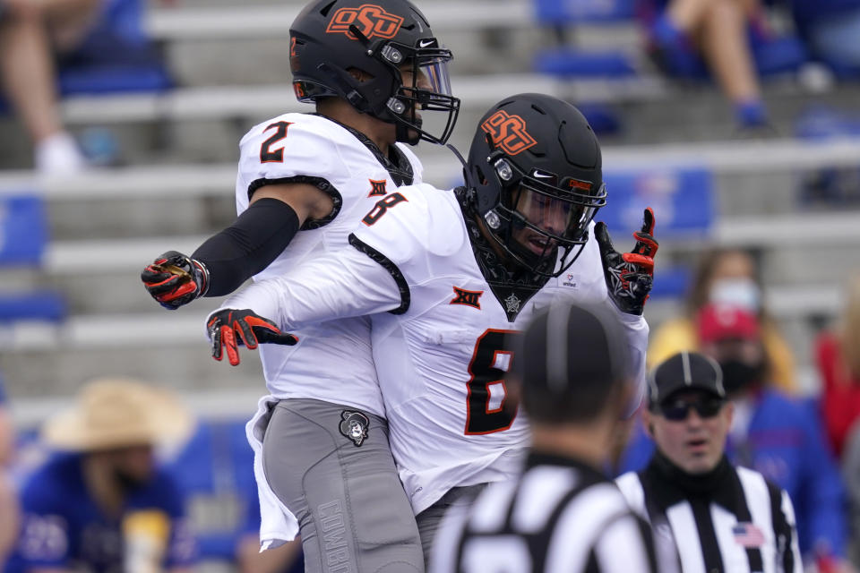 Oklahoma State wide receivers Tylan Wallace (2) and Braydon Johnson (8) celebrate a touchdown during the first half of an NCAA college football game against Kansas in Lawrence, Kan., Saturday, Oct. 3, 2020. (AP Photo/Orlin Wagner)