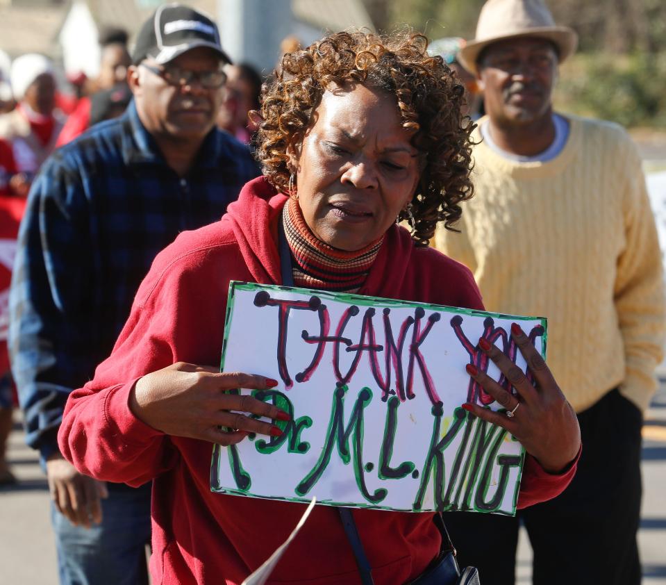 Betty Wells carries a sign thanking Martin Luther King Jr. during the Unity March honoring Martin Luther King Jr. Monday, Jan. 15, 2018 in Tuscaloosa. [Staff Photo/Gary Cosby Jr.]