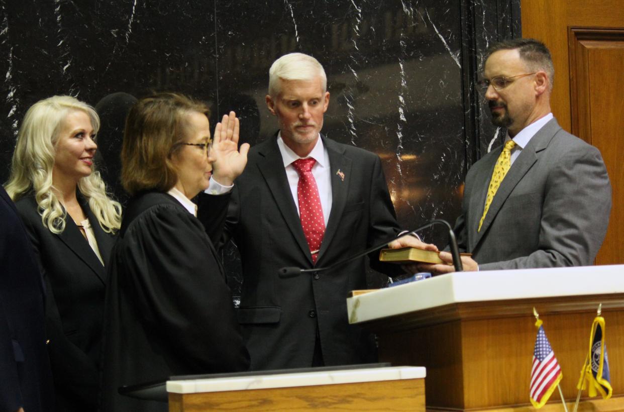 State Rep. J. Michael Davisson (R-Salem) (second from right) takes the oath of office with Indiana Supreme Court Justice Loretta H. Rush (second from left) presiding during a swearing-in ceremony at the Statehouse on Monday, Nov. 8. Davisson was joined by family friends Christopher (far right) and Elizabeth (far left) Williams.