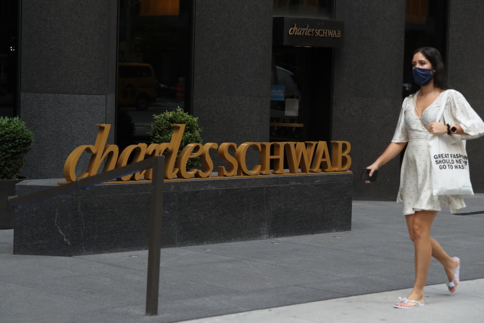 NEW YORK, NEW YORK - JULY 01: A person walks by the Charles Schwab logo in midtown as New York City moves into Phase 2 of re-opening following restrictions imposed to curb the coronavirus pandemic on July 1, 2020 in New York, New York. Phase 2 permits the re-opening of office jobs, real estate services, in-store retail services such as rentals, repairs and hair salons, and outdoor dining. (Photo by Rob Kim/Getty Images)