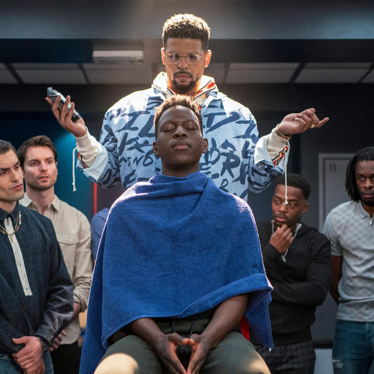 Kola Bokkini as captain Isaac McAdoo gives Sam Obisanya a haircut.  (Colin Hutton / Apple TV+)