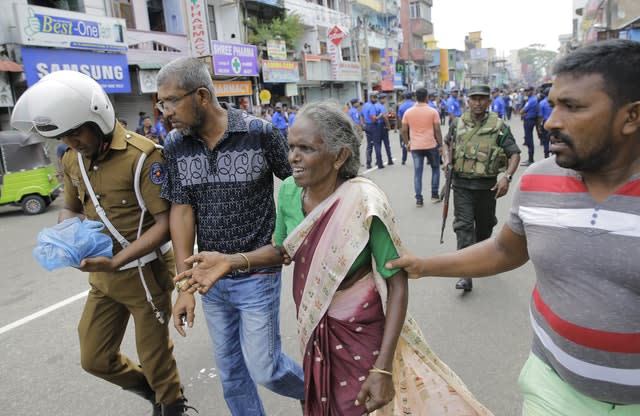 An elderly woman is helped near St Anthony’s Shrine in Colombo 