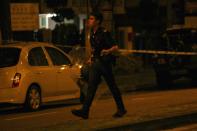 A police officer walks with a riot shield following a riot in Singapore's Little India district, December 9, 2013. Local media said a mob of about 400 set fire to an ambulance and police cars during the riot on Sunday, which started after a bus knocked down a pedestrian. REUTERS/Rob Dawson (SINGAPORE - Tags: CIVIL UNREST)