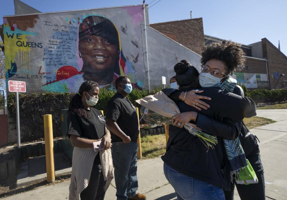 Director Sophia Nahli Allison, right, hugs Shinese Harlins Kilgore next to the mural.