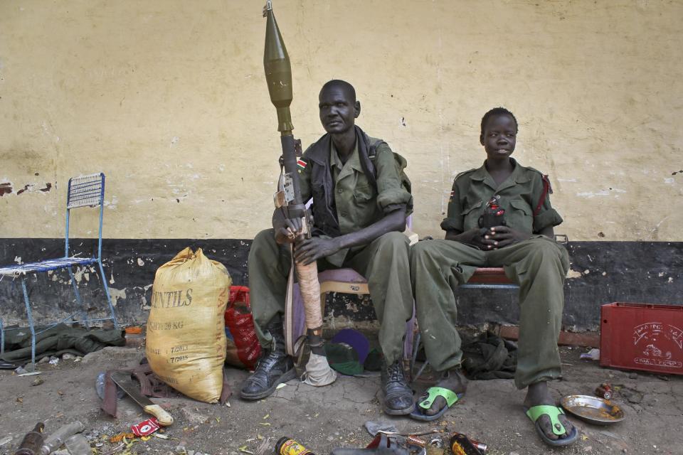 In this photo taken Wednesday, Feb. 26, 2014, rebels sit in the now-emptied hospital in Malakal, South Sudan. A week ago forces loyal to former vice president Riek Machar retook Malakal in a bloody assault that forced the government army to make what it labeled a tactical withdrawal, while Human Rights Watch said Thursday that both government and rebel forces are responsible for serious abuses that may amount to war crimes for atrocities committed in Malakal and Bentiu, another capital of an oil-producing state, despite a cease-fire signed in January. (AP Photo/Ilya Gridneff)