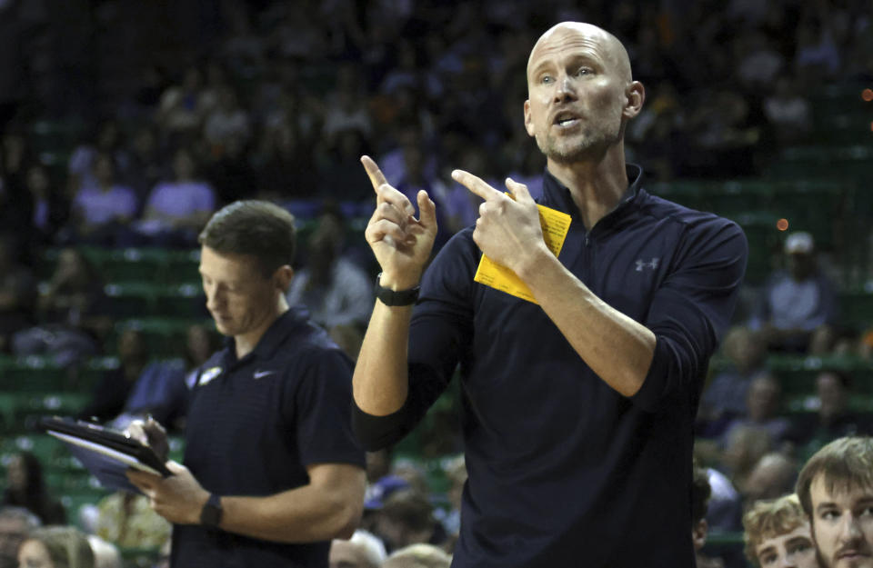 John Brown head coach Jason Beschta sends in an offensive play against Baylor in the first half of an NCAA college basketball game, Thursday, Nov. 9, 2023, in Waco, Texas. (AP Photo/Rod Aydelotte)