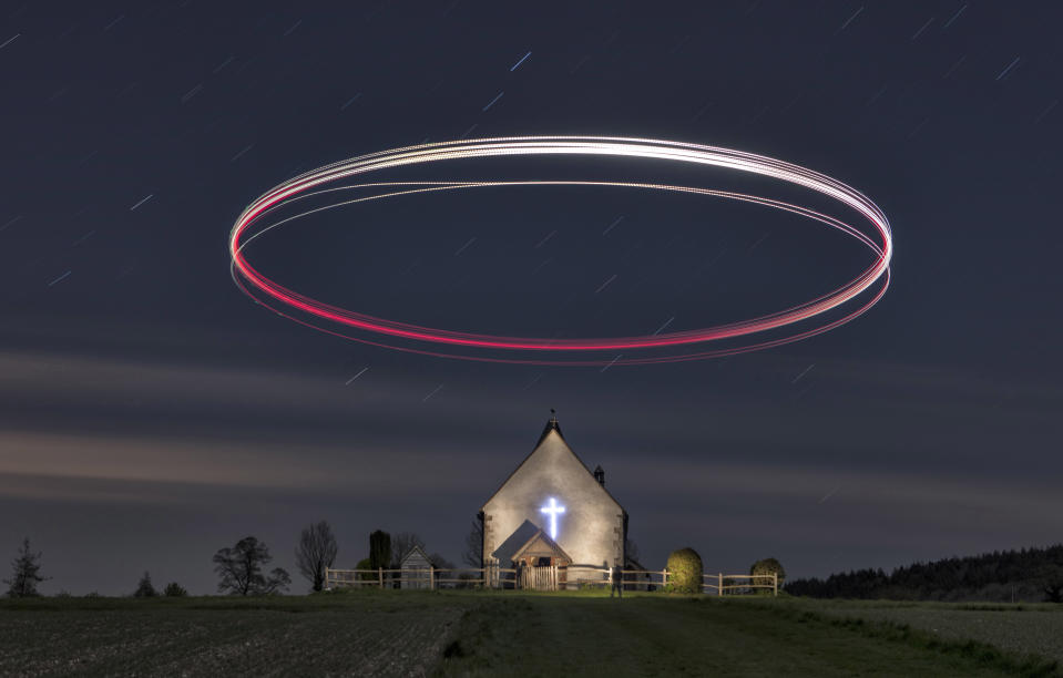 A picture of a drone, rather than by one. The drone, captured over a five-minute exposure, forms a halo over St Hubert's Church in Hampshire.