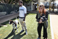 Ro Mantooth and Rachel Niebur, and their dogs, Champ, left, and Petey, hang out at a small dog park, formerly a city bus depot and now with the nonprofit People Assisting the Homeless, in the Venice section of Los Angeles on Tuesday, April 5, 2022. It was the first facility of its kind in Los Angeles County to allow homeless shelter residents to bring animal companions. In addition to Petey and Champ, there are eight other dogs and one cat at the Venice PATH shelter. (AP Photo/Richard Vogel)