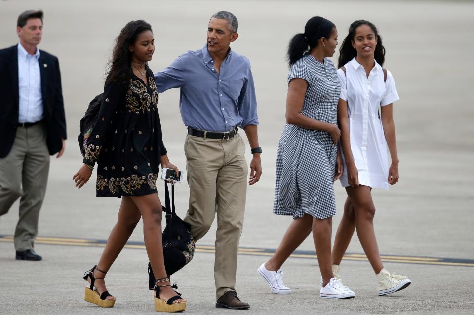 Barack and Michelle Obama, with their daughters, Sasha, far left, and Malia, prepare to board Air Force One in Bourne, Mass., on Aug. 21, 2016, after vacationing on Martha's Vineyard.