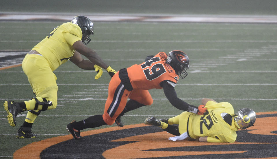 CORVALLIS, OREGON - NOVEMBER 27: Linebacker Andrzej Hughes-Murray #49 of the Oregon State Beavers sacks Quarterback Tyler Shough #12 of the Oregon Ducks during the first half of the game at Reser Stadium on November 27, 2020 in Corvallis, Oregon. (Photo by Steve Dykes/Getty Images)