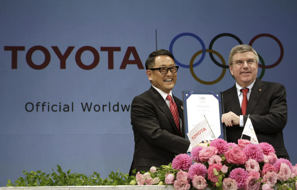 FILE - Toyota President and CEO Akio Toyoda, left, and IOC President Thomas Bach pose with a signed document during a press conference in Tokyo, on March 13, 2015 as Toyota signed on as a worldwide Olympic sponsor in a landmark deal, becoming the first car company to join the IOC's top-tier marketing program. Toyota will end its massive sponsorship deal with the International Olympic Committee after this year's Paris Olympics, according to reports in Japan. (AP Photo/Eugene Hoshiko, File)