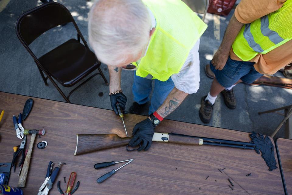 Bruce Travis dismantles a firearm during an event at the Christ United Methodist Church in Salt Lake City on Saturday.