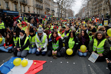 FILE PHOTO: Protesters wearing yellow vests kneel on the street as they take part in a demonstration in Paris, France, January 6, 2019. REUTERS/Gonzalo Fuentes/File Photo