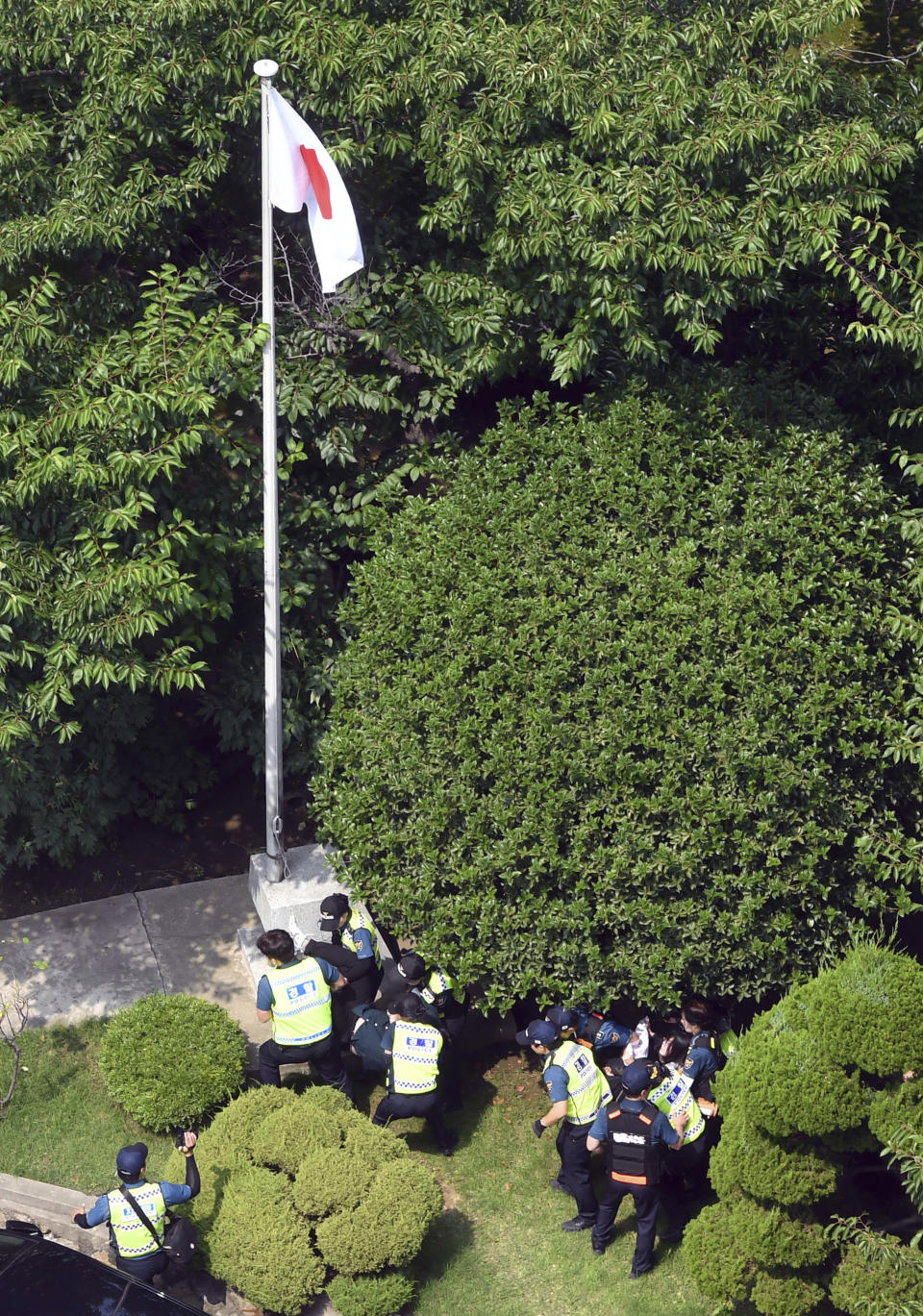 CORRECTS DATE - South Korean police officers detain protesters at backyard of Japanese consulate in Busan, South Korea, Monday, July 22, 2019. South Korean police say they've detained six people for allegedly illegally entering a Japanese diplomatic facility in South Korea. (Huh Kyung-min/Newsis via AP)