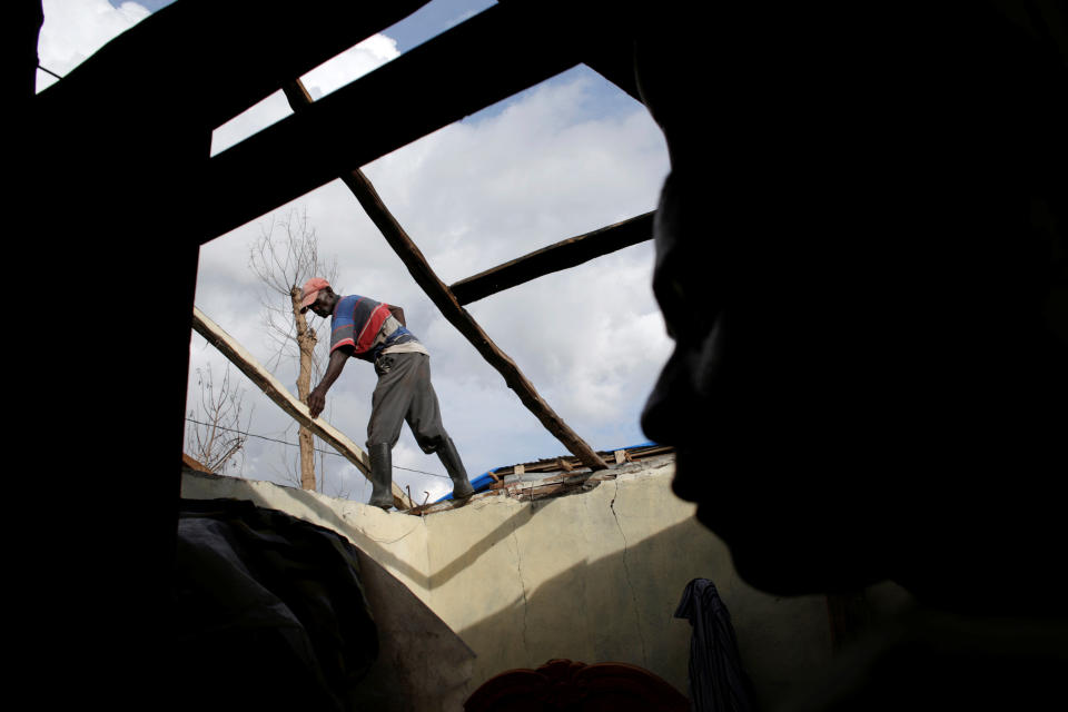 A boy looks at a man as he rebuilds&nbsp;the roof of&nbsp;a house affected by Hurricane Matthew in Damassins&nbsp;on Oct. 22, 2016.