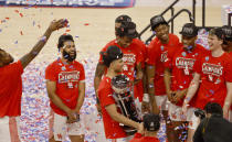 Tournament MVP Houston guard Quentin Grimes (24) holds the championship trophy and celebrates with teammates following the team's win over Cincinnati an NCAA college basketball game in the final round of the American Athletic Conference men's tournament Sunday, March 14, 2021, in Fort Worth, Texas. (AP Photo/Ron Jenkins)