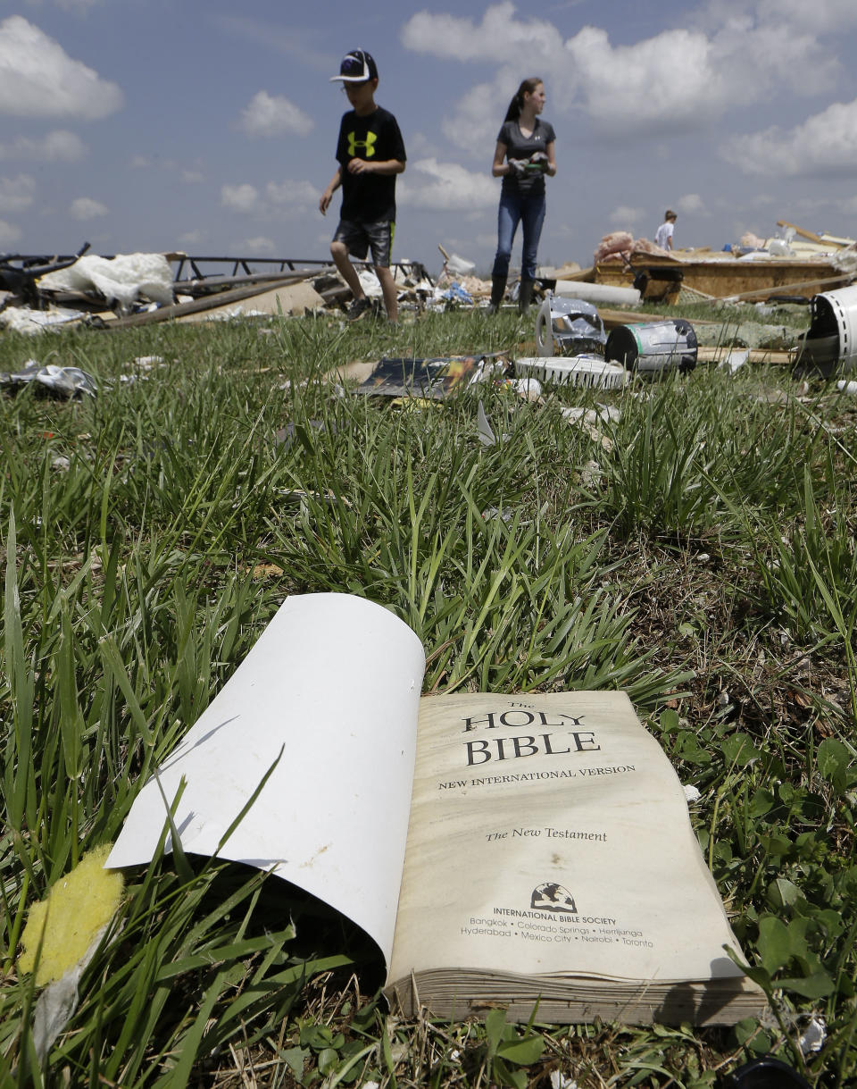 A Bible lies on the ground as people salvage items from Grace Falls Church Tuesday, April 29, 2014, in Fayetteville, Tenn. The church was destroyed by storms Monday. (AP Photo/Mark Humphrey)