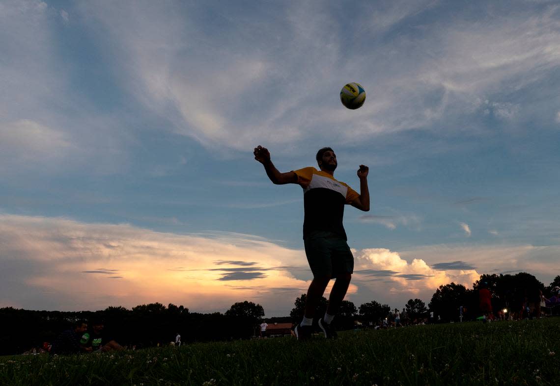 A person plays with a soccer ball as the sun sets during an Independence Day celebration at Dorothea Dix Park on Tuesday, July 4, 2023, in Raleigh, N.C. Kaitlin McKeown/kmckeown@newsobserver.com