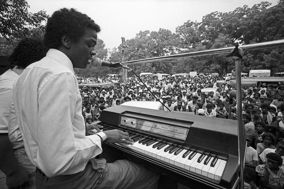 Musical entertainers are seen performing on a stage before a crowd at the Juneteenth celebration in Sycamore Park in Fort Worth in 1982.