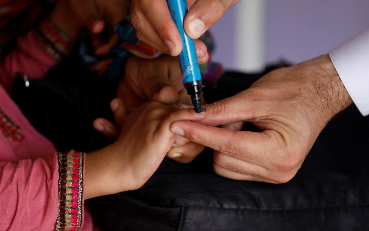 A girl has her finger marked after being given the polio vaccine - REUTERS