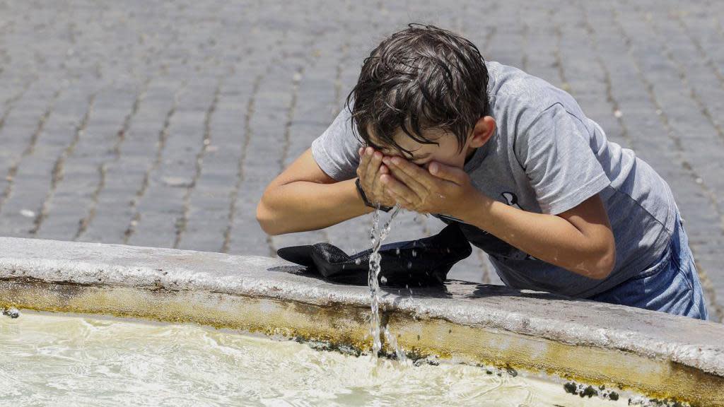 Boy drinking water during heatwave