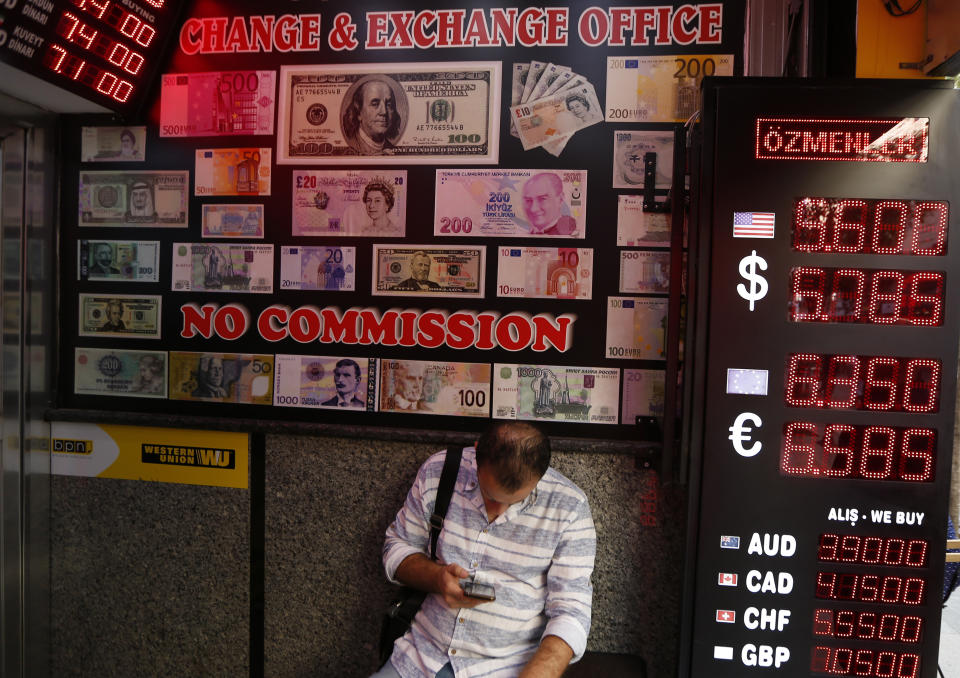 A man uses his mobile as he sits in a currency exchange shop in Istanbul, Thursday, Aug. 16, 2018. Beset by a weak currency and tension with the United States, Turkey is reaching out to Europe in an attempt to shore up relations with major trading partners despite years of testy rhetoric and a stalled bid for EU membership. The overtures by Turkish President Recep Tayyip Erdogan, who has harshly criticized Germany and other European nations in the past, are part of a diplomatic campaign to capitalize on international unease over U.S. President Donald Trump and American tariff disputes. (AP Photo/Lefteris Pitarakis)