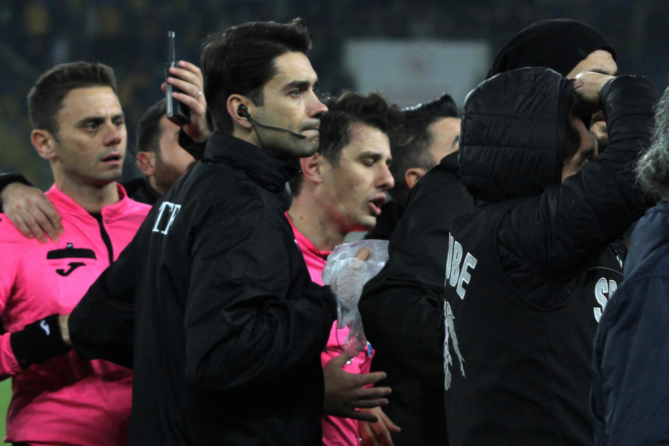 Turkish referee Halil Umut Meler, center, is helped to leave the pitch after being punched by MKE Ankaragucu president Faruk Koca at the end of the Turkish Super Lig soccer match between MKE Ankaragucu and Caykur Rizespor in Ankara, Monday, Dec. 11, 2023. The Turkish Football Federation has suspended all league games in the country after a club president punched the referee in the face at the end of a top-flight match. Koca was arrested Tuesday, Dec. 12, 2023, along with two other people on charges of injuring a public official following questioning by prosecutors. (Cem Gecim/IHA via AP)
