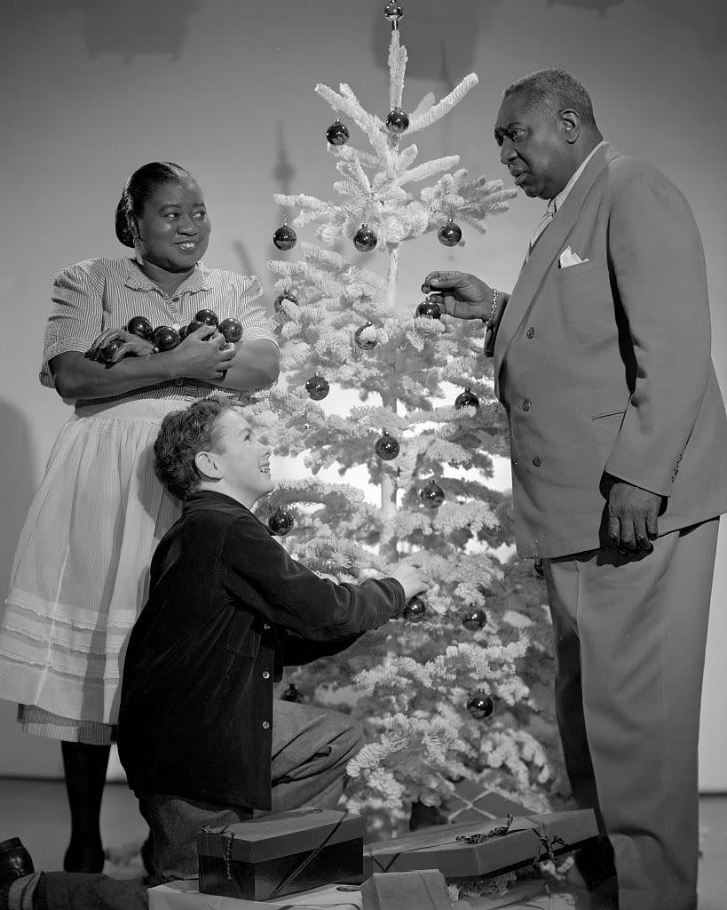 <p>Hattie McDaniel looks flush with yuletide joy as she decorates a Christmas tree with her <em>Beulah</em> costars in 1947. </p>