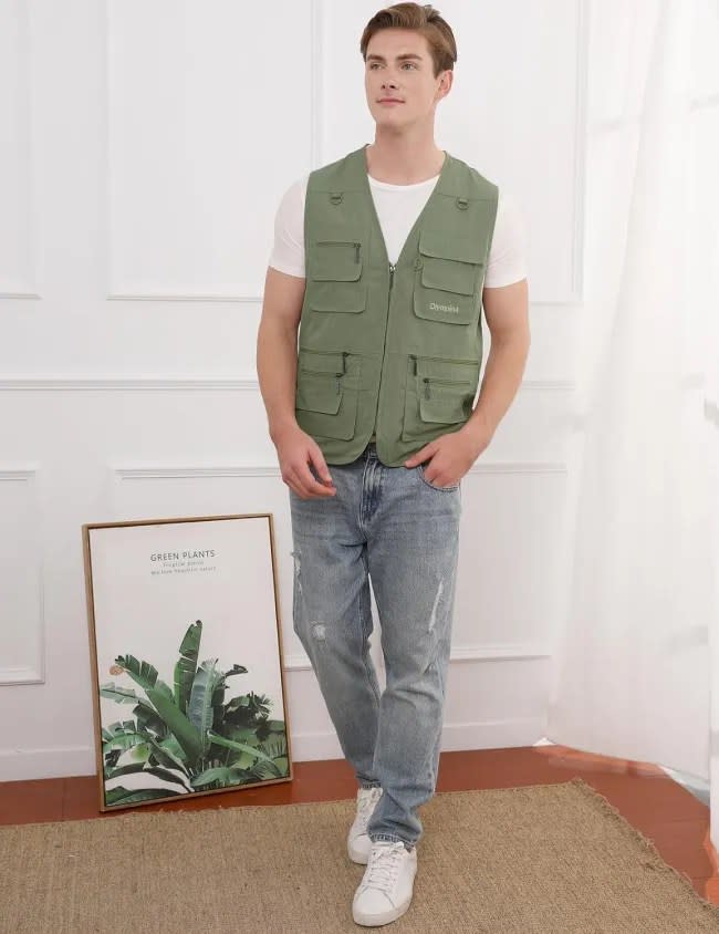 A man wearing a green fishing vest.