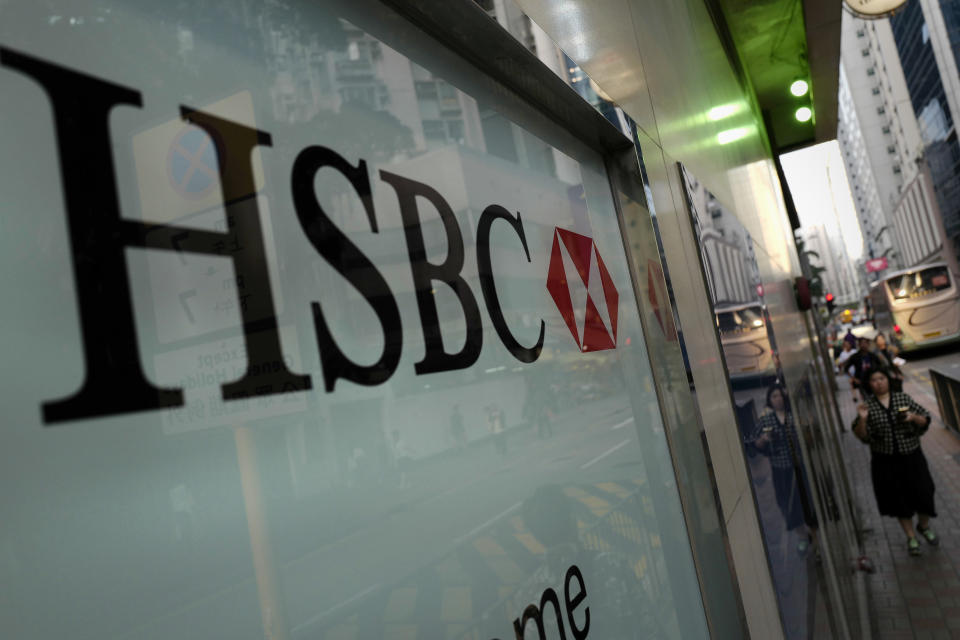 A woman walks past a branch of HSBC bank