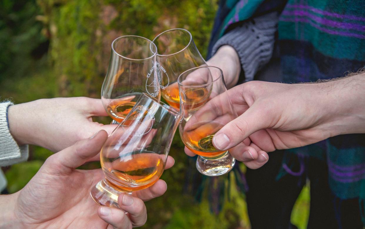 Friends enjoy a dram of whisky at the Clachaig Inn, Glencoe