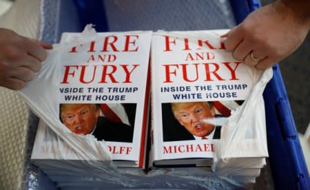 A shop worker opens a package containing copies of Michael Wolff's book 'Fire And Fury' as they go on sale inside a branch of the Waterstones book store in Liverpool, Britain, January 11, 2018. REUTERS/Phil Noble