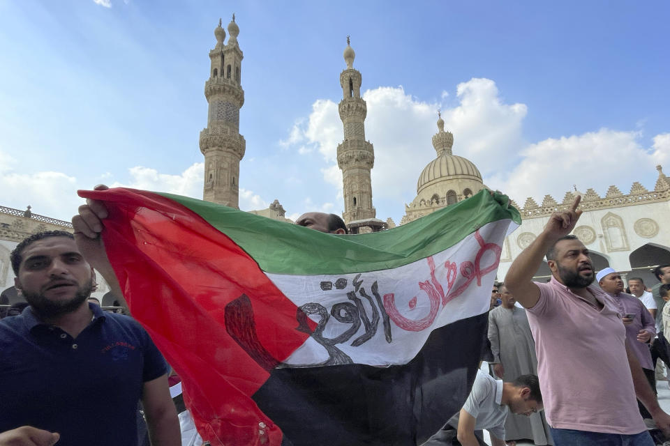Protesters hold a Palestinian flag reading ''Al-Aqsa flood'' in Arabic, as they leave Friday prayers at Azhar mosque, the Sunni Muslim world's premier Islamic institution, in Cairo, Egypt, Friday, Oct. 13, 2023. (AP Photo/Amr Nabil)