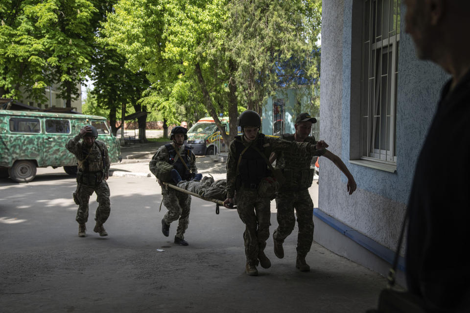 Ukrainian servicemen carry an injured comrade on A stretcher to the hospital after an attack by Russian forces in Donetsk region, Ukraine, on Monday, May 9, 2022.(AP Photo/Evgeniy Maloletka)