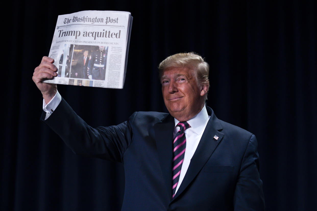 President Trump holds up a newspaper with the headline that reads "Trump acquitted" during the 68th annual National Prayer Breakfast at the Washington Hilton on Thursday. (AP Photo/ Evan Vucci)