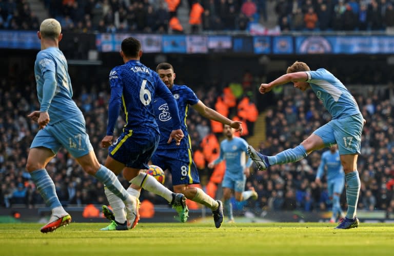 O meia belga do Manchester City Kevin De Bruyne (dir.) marca o gol da vitória sobre o Chelsea no Etihad Stadium em Manchester, em 15 de janeiro de 2022 (AFP/Oli SCARFF)