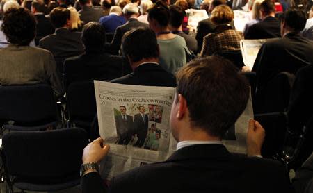 A delegate reads a newspaper in the main hall on the opening day of The Conservative Party annual conference in Manchester, northern England September 29, 2013. REUTERS/Phil Noble