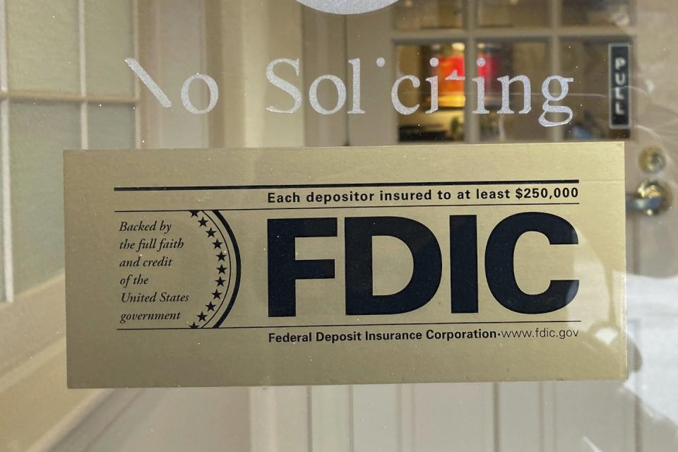 An FDIC sign is posted on a window at a Silicon Valley Bank branch in Wellesley, Mass., on March 11, 2023. (AP Photo/Peter Morgan)